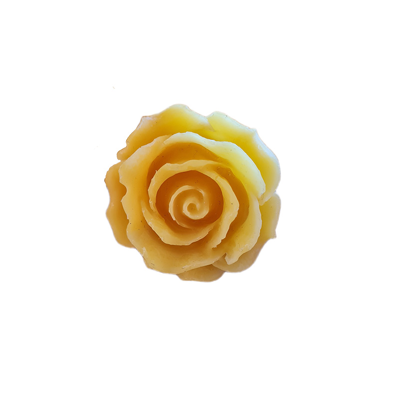 Carved beeswax rose shaped like a flower, displayed on white background